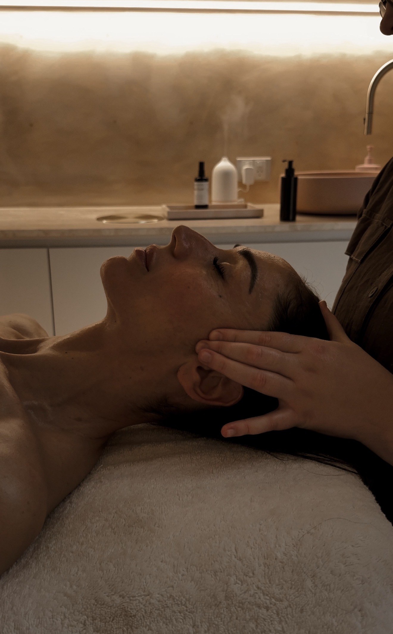 Client relaxing during a facial massage in a SKYNN treatment room in Albion, Brisbane